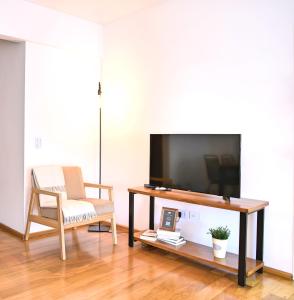 sala de estar con TV, silla y mesa en Garage incluido! Buenos Aires - Villa Urquiza en Buenos Aires