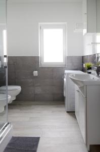 łazienka z umywalką, toaletą i wanną w obiekcie Apartman Maria 2 w Rabie