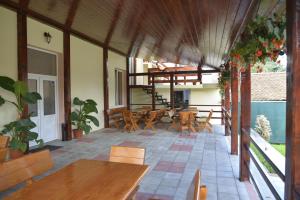 an outdoor patio with wooden tables and chairs at Pensiunea Class in Sălişte