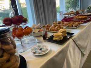 uma mesa coberta com pratos de pastelaria e outros alimentos em Le Ceramiche - Hotel Residence ed Eventi em Montalto Uffugo