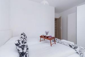 a white room with a bed and a table at Family Apartment with Parking & Terrace by Renters in Kraków
