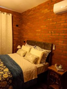 a bedroom with a bed and a brick wall at Chale Greifswald Pomerode in Pomerode