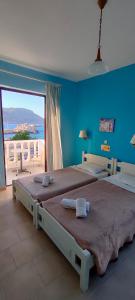 1 dormitorio con 2 camas y pared azul en P i g a d i a B a y, en Karpathos