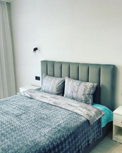 sypialnia z łóżkiem z niebieską kołdrą i poduszkami w obiekcie Люкс для вибагливих в центрі w mieście Łuck