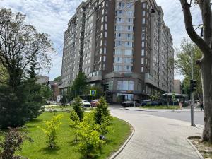 a large building on a city street with a grass median at Dendrarium Park Apartment in Chişinău