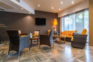 a living room with chairs and a table and a couch at Hôtel Bahia in Villeneuve-Loubet