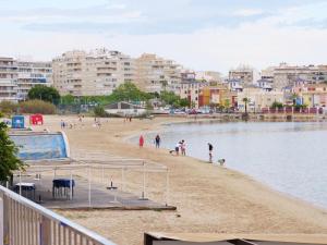 a group of people on a beach near a body of water at Esmeralda Beach in Torrevieja
