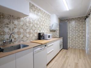 a kitchen with white cabinets and a sink at Esmeralda Beach in Torrevieja