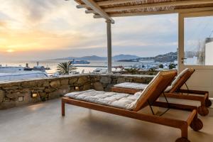 a room with two chairs and a view of the beach at Supreme Mykonos Town House with Views & Pool & Parking in Mýkonos City
