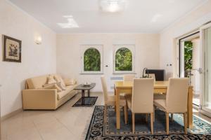 uma sala de estar com uma mesa e um sofá em Villa Perla Apartments with balcony em Ičići