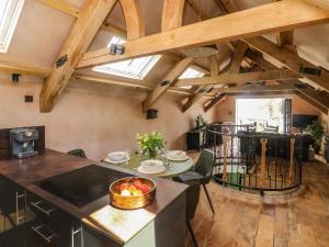 a kitchen with wooden ceilings and a table with a bowl of fruit at Becket's Barn in Okehampton
