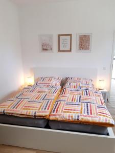 łóżko z kolorową kołdrą i dwoma lampami w obiekcie FeWo Greiwe w mieście Telgte