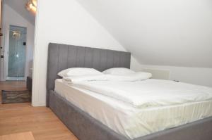 1 dormitorio con 1 cama grande con sábanas blancas en Forest Boutique en Piteşti