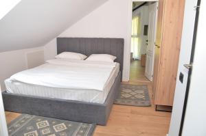 1 dormitorio con 1 cama con sábanas blancas en Forest Boutique en Piteşti