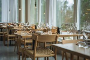 a dining room with tables and chairs with wine glasses at Skepparholmen Nacka in Nacka