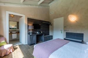 una camera con letto, scrivania e TV di Relais Le Coste a Lavagno