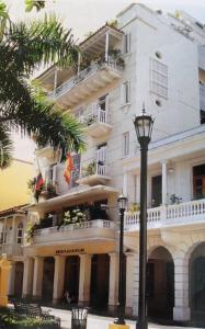 duży biały budynek z balkonem i światłem ulicznym w obiekcie Bello apartamento corazón de Cartagena colonial w mieście Cartagena de Indias