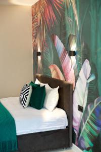 - une chambre avec un lit doté d'oreillers et d'un papier peint tropical dans l'établissement Terracotta & Rooms комфортная студия для отдыха, à Uralsk