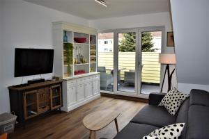 ein Wohnzimmer mit einem Sofa und einem Flachbild-TV in der Unterkunft Heiligenbergblick in Heidelberg