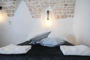 1 dormitorio con 1 cama con 2 almohadas en CASA FLAMI' 4 en Ostuni