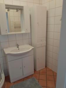 a white bathroom with a sink and a mirror at Ferienwohnung Schuhhaus Ganster in Mariazell