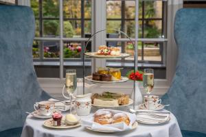 a table with a tray of pastries and glasses of wine at The Holt Hotel in Steeple Aston