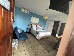 una camera con letto e parete blu di Andora Inn Bed and Breakfast a Durban
