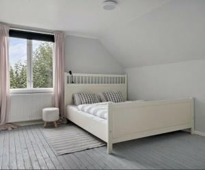 una camera bianca con un grande letto e una finestra di Ferienhaus Alfred a Ryd