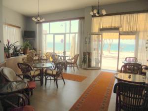 ein Restaurant mit Tischen und Stühlen und Meerblick in der Unterkunft Hotel Arsenakos in Neapolis