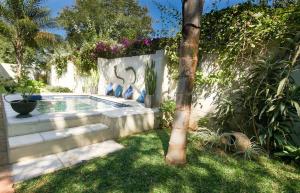 a swimming pool in a yard with a tree at Victoria Falls Holiday Home in Victoria Falls