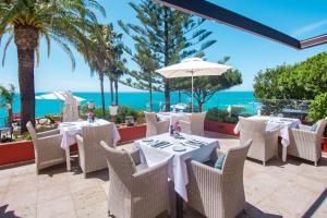 a restaurant with tables and chairs with the ocean in the background at Boutique Hotel Vivenda Miranda in Lagos