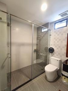 a bathroom with a toilet and a glass shower at Wildbird Hotel in Tràm Chim