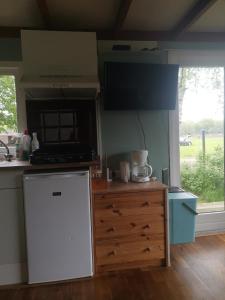 a kitchen with a white refrigerator and a counter at Zilver'n Plekkie in Zeyen