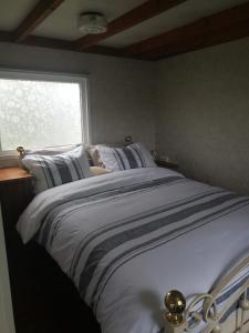 ein großes Bett in einem Schlafzimmer mit Fenster in der Unterkunft Zilver'n Plekkie in Zeyen