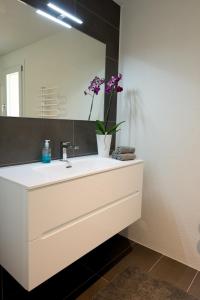 a bathroom with a white sink and a mirror at Casa Bellavista in Pugerna