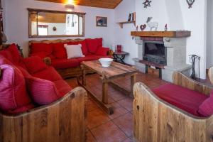 a living room with a red couch and a fireplace at Le Cocon Detached chalet (6p). 3 bedrooms and 2 bathrooms in Peisey-Nancroix