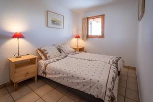 a bedroom with a bed and two lamps and a window at Le Cocon Detached chalet (6p). 3 bedrooms and 2 bathrooms in Peisey-Nancroix