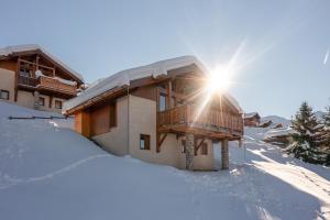 a ski lodge in the snow with the sun shining at Le Cocon Detached chalet (6p). 3 bedrooms and 2 bathrooms in Peisey-Nancroix