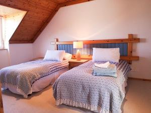 a bedroom with two beds and a table with a lamp at 4 bedroomed holiday home close to the beach in Waterville