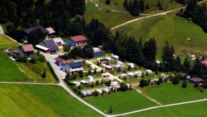 una vista aérea de una casa en una colina verde en App 1 - Farbennest mit Frühstück Teeküche, Sommerbergbahnen inkl en Tannheim