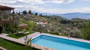 an outdoor swimming pool with a view of the water at Calypso Villa with Jacuzzi Pool & Sea View in Nerotriviá