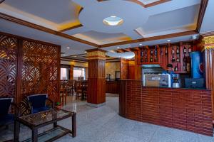 a man is standing at the counter of a restaurant at Satkar Hotel and Spa in Kathmandu