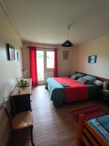 1 dormitorio con 1 cama y una ventana con cortinas rojas en au bonheur du cedre, en Saint-Lattier