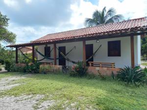 ein kleines Haus mit einer Bank davor in der Unterkunft POUSADA DO BETO in Atins