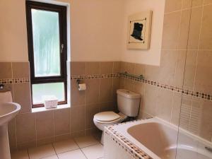 e bagno con servizi igienici, lavandino e vasca. di Holiday home within easy walking distance to Kenmare a Kenmare
