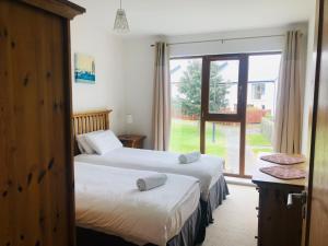 2 letti in una camera con finestra di Holiday home within easy walking distance to Kenmare a Kenmare