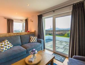 a living room with a couch and a sliding glass door at Large house with adjoining cottage close to Waterville in Waterville