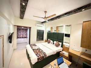 a bedroom with a bed and a laptop on a desk at Hotel Vashi Inn in Navi Mumbai