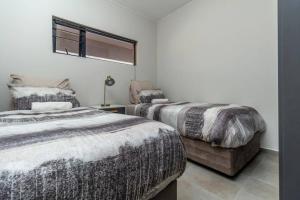 a bedroom with two beds and a window at Smart apartment 322 in Midrand