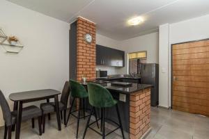 a kitchen with a bar with green chairs in it at Smart apartment 322 in Midrand